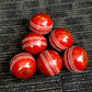 Pack of 6 red cricket balls from Black Ash Premium grade, featuring genuine leather with a 4-piece construction for excellent shape retention. These premium quality, machine-stitched balls are designed for 30 to 35 overs, meet MCC regulations, and each ball weighs 156 grams (5.5 oz).