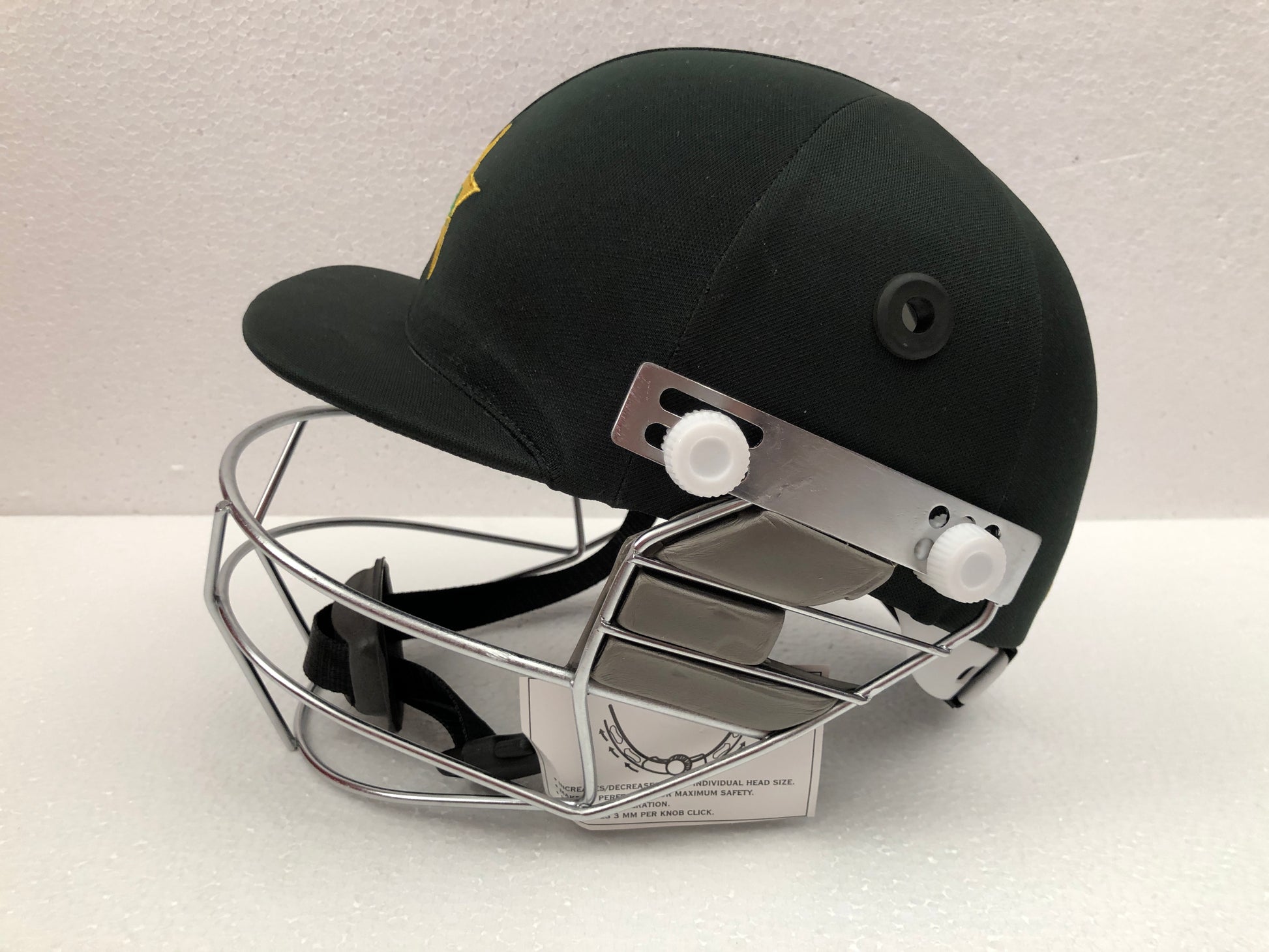 Black Ash custom International adjustable helmet, featuring a high impact polypropylene shell and chrome finish steel grill with 8 micro adjustments for enhanced protection and visibility, sweat-absorbent padding, and soft ear protection, adjustable to fit sizes 52-58 cm.