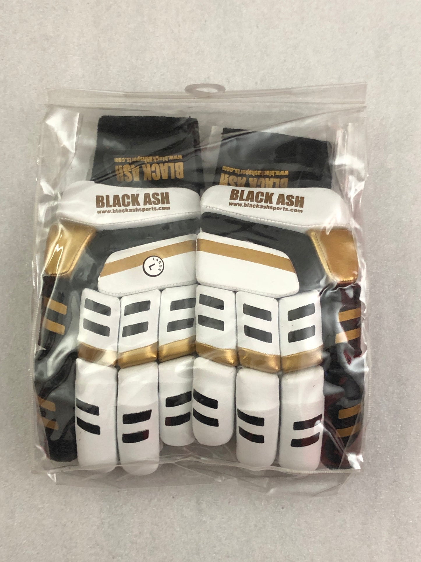 White/Gold Cricket Batting Gloves by Black Ash, with light-weight high-density foam, strong inserts in fingers for added protection, full leather palm and thumb, two-piece thumb for comfort, in white and gold.