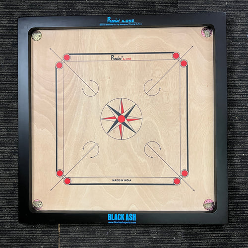 PRECISE Excel A-One carrom board with a 6mm thick special selected A-One waterproof ply, measuring 32x32 inches overall with a 29x29 inch playing area, 1.5-inch borders, and strong hand-knitted wool nets. Includes a striker and a set of coins, featuring plastic feet for elevation.