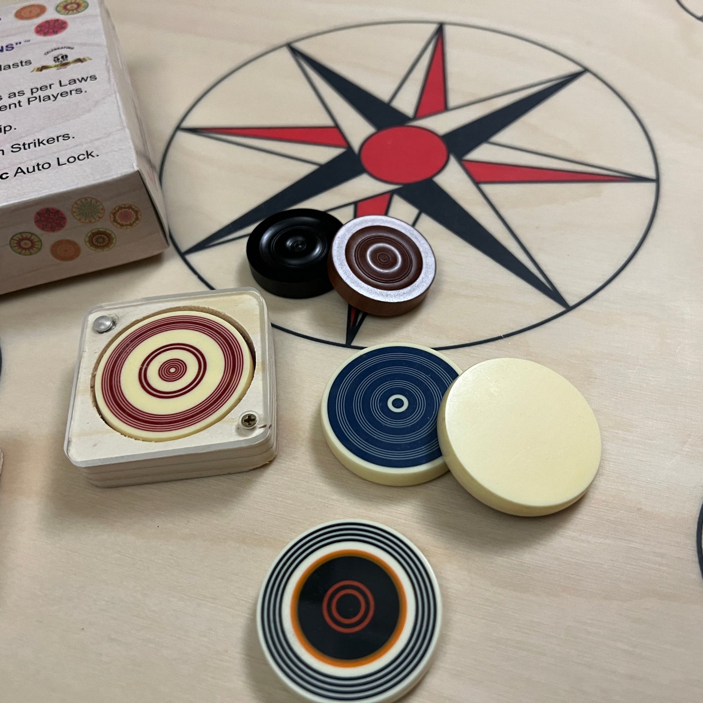 Professional tournament carrom striker by Precise, packed in a unique magnetic lock wooden box, each with an elegant design, available through Black Ash Sports.