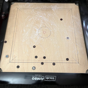 Black Ash 'Jumbo' high-end special edition carrom board by SISCAA, made of English Birchwood, 51x51 inches with a 41x41 inch playing area, 12mm sheet thickness, and 5-inch borders. Includes premium finish, fast rebound borders, heavy-duty back support, high-end coins, and 2 strikers.